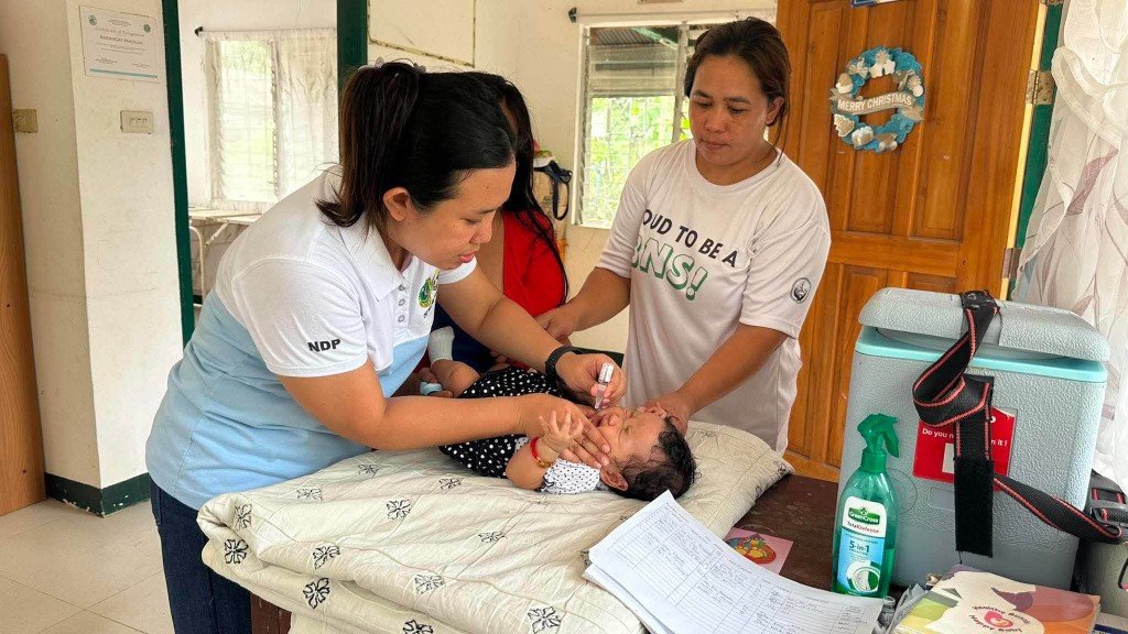 Healthcare workers providing infant care at a barangay health center